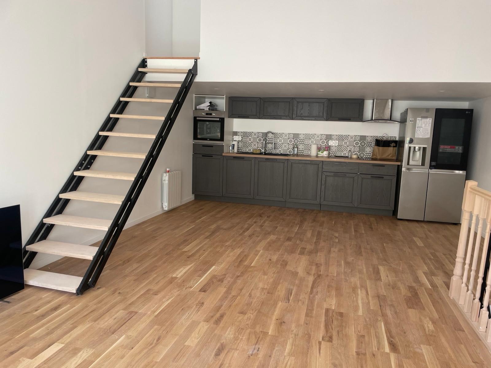 Cuisine après rénovation, avec escalier en bois.